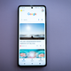 A photo of the Edge+ with the Google Feed on screen